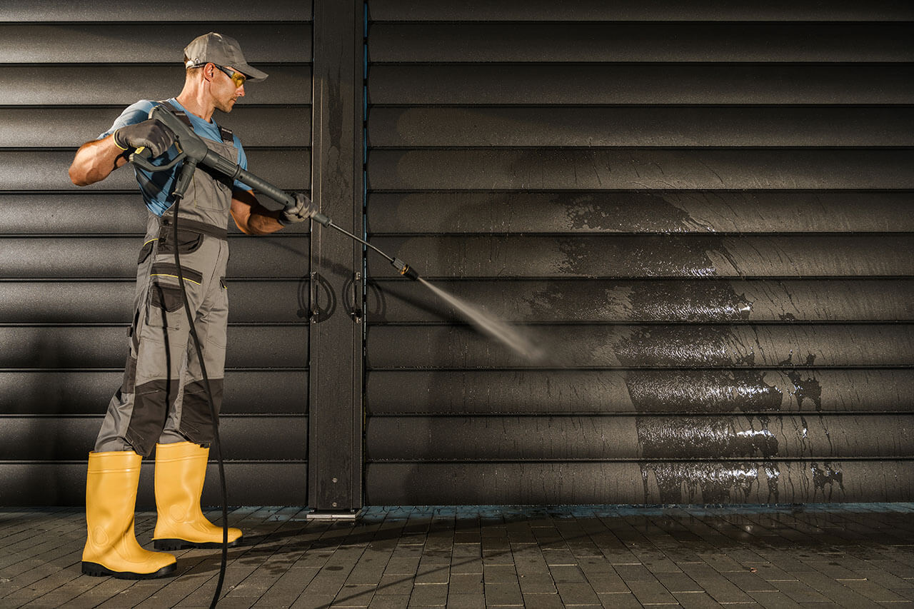 Professional pressure washing service cleaning a house's siding, showcasing the difference on the cleaned surface.